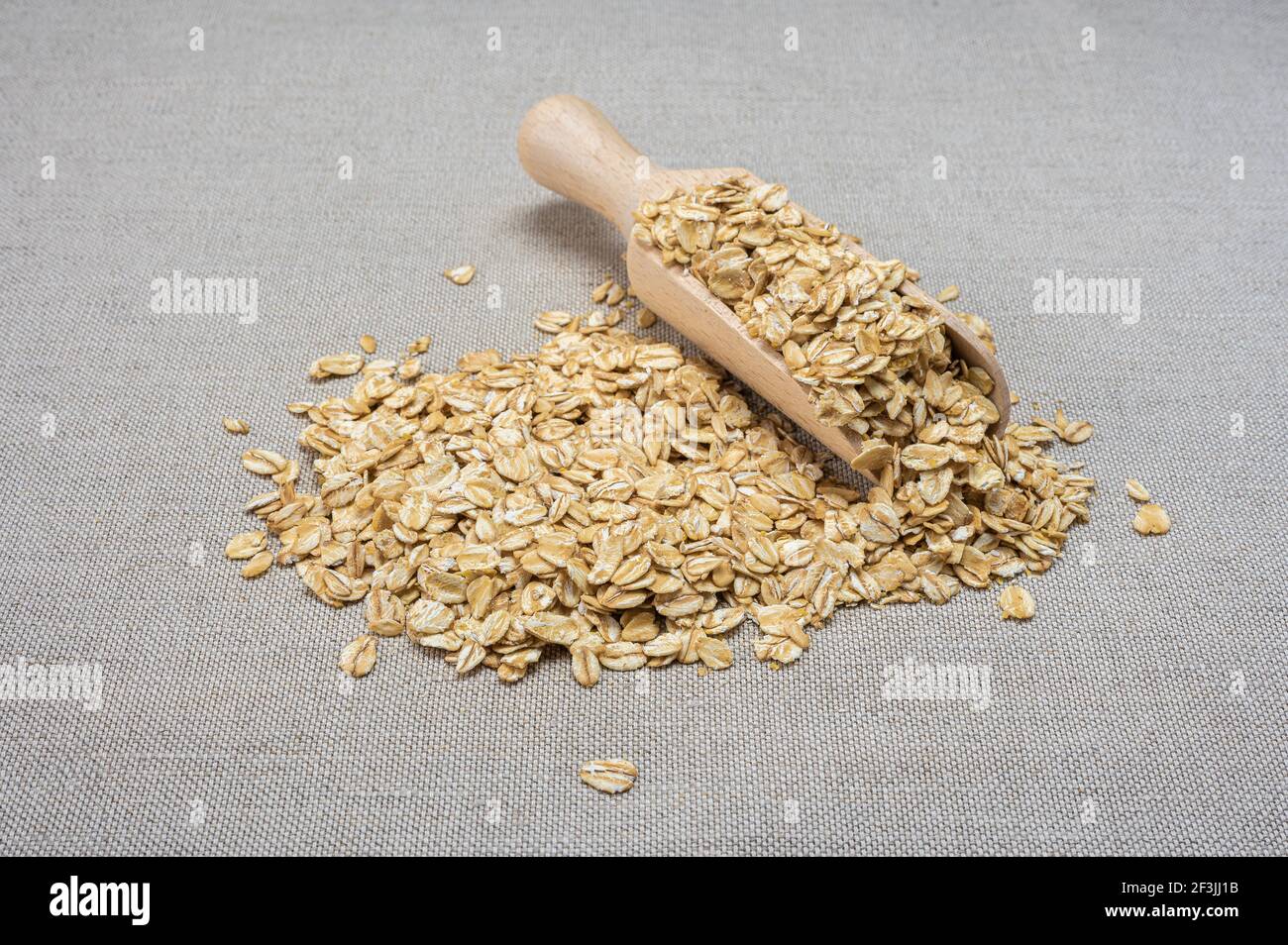 Cuillère en bois avec flocons d'avoine secs. Flocons d'avoine crus organiques crus. Cuisson avoine porridge concept Banque D'Images