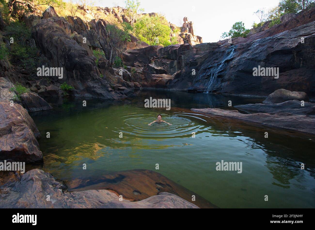Une femme nageant au-dessus de la chute d'eau de Gunlom im Kakadu National Park En Australie Banque D'Images
