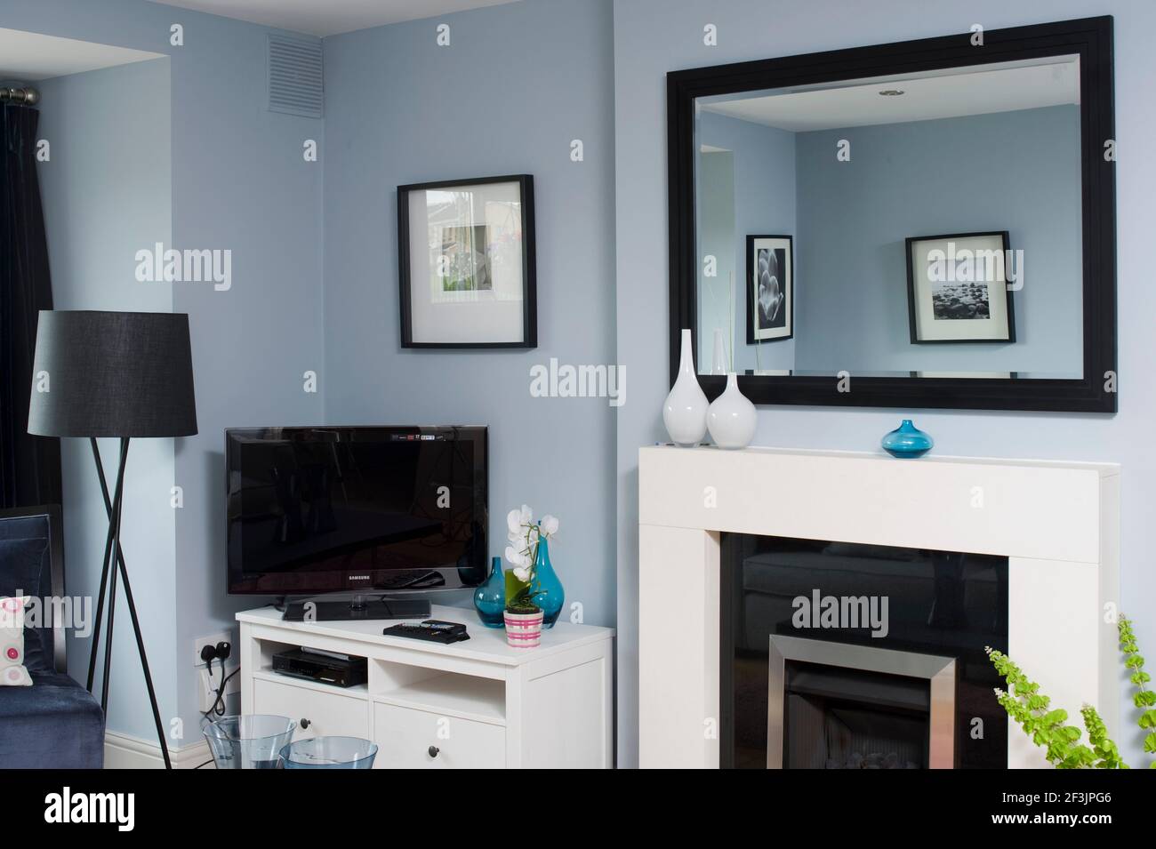 Salon avec TV sur le tableau de côté, grand miroir mural, lampe de côté et  cheminée photo par Kevin Mcfeely Photo Stock - Alamy
