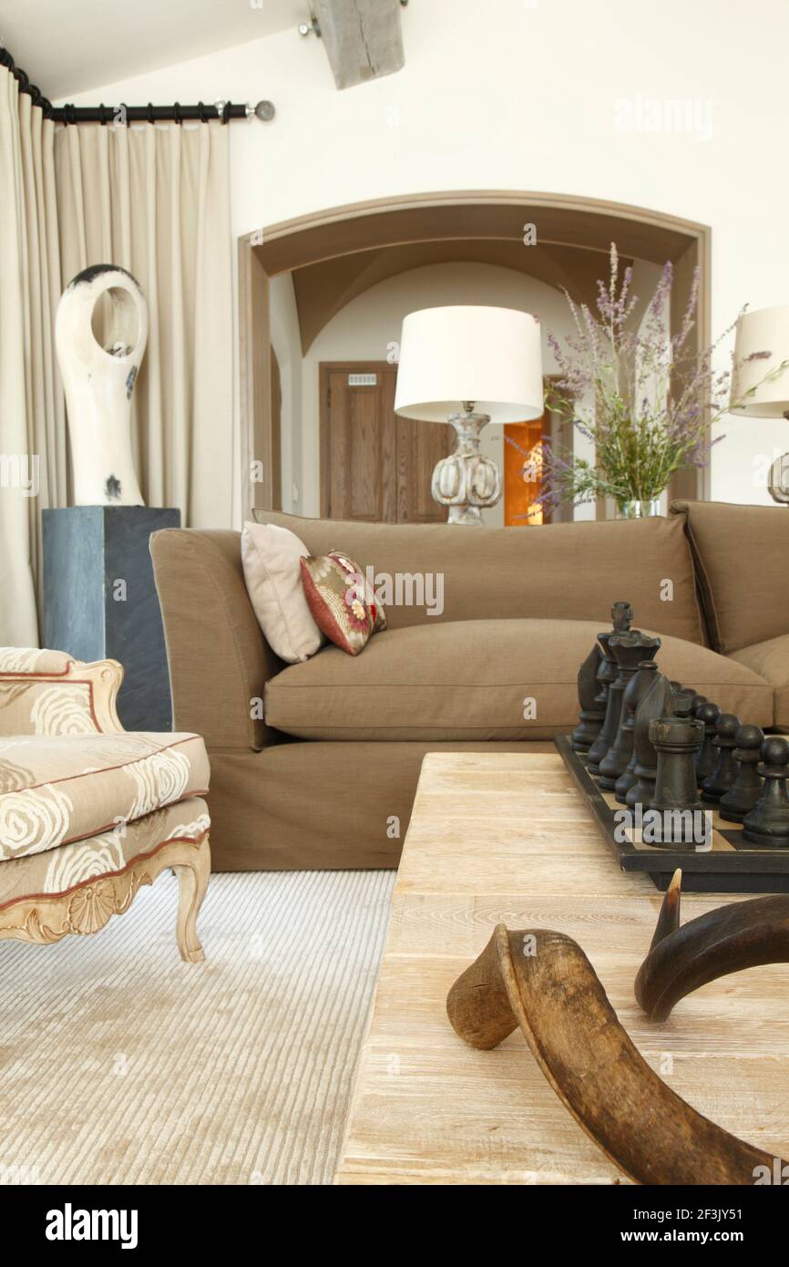 Cornes et échecs géants sur table basse avec lampe sur table encadrée par une arcade menant à la salle en arrière-plan | | Designer : Michael Nicholas Banque D'Images