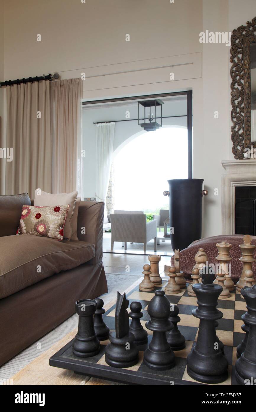 Échecs géants sur table basse dans le salon, avec vue sur la véranda | | Designer : Michael Nicholas Banque D'Images