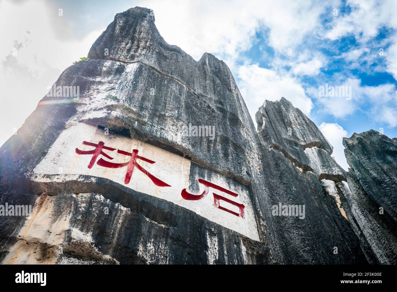 Vue panoramique de la formation de calcaire écrit Shilin en caractères chinois rouges au grand parc forestier de pierre de Shilin dans le Yunnan Chine (traduction : pierre pour Banque D'Images