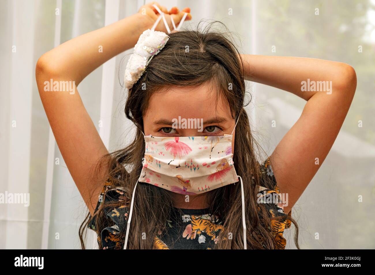Jeune fille s'adaptant à un masque de visage fait maison Banque D'Images