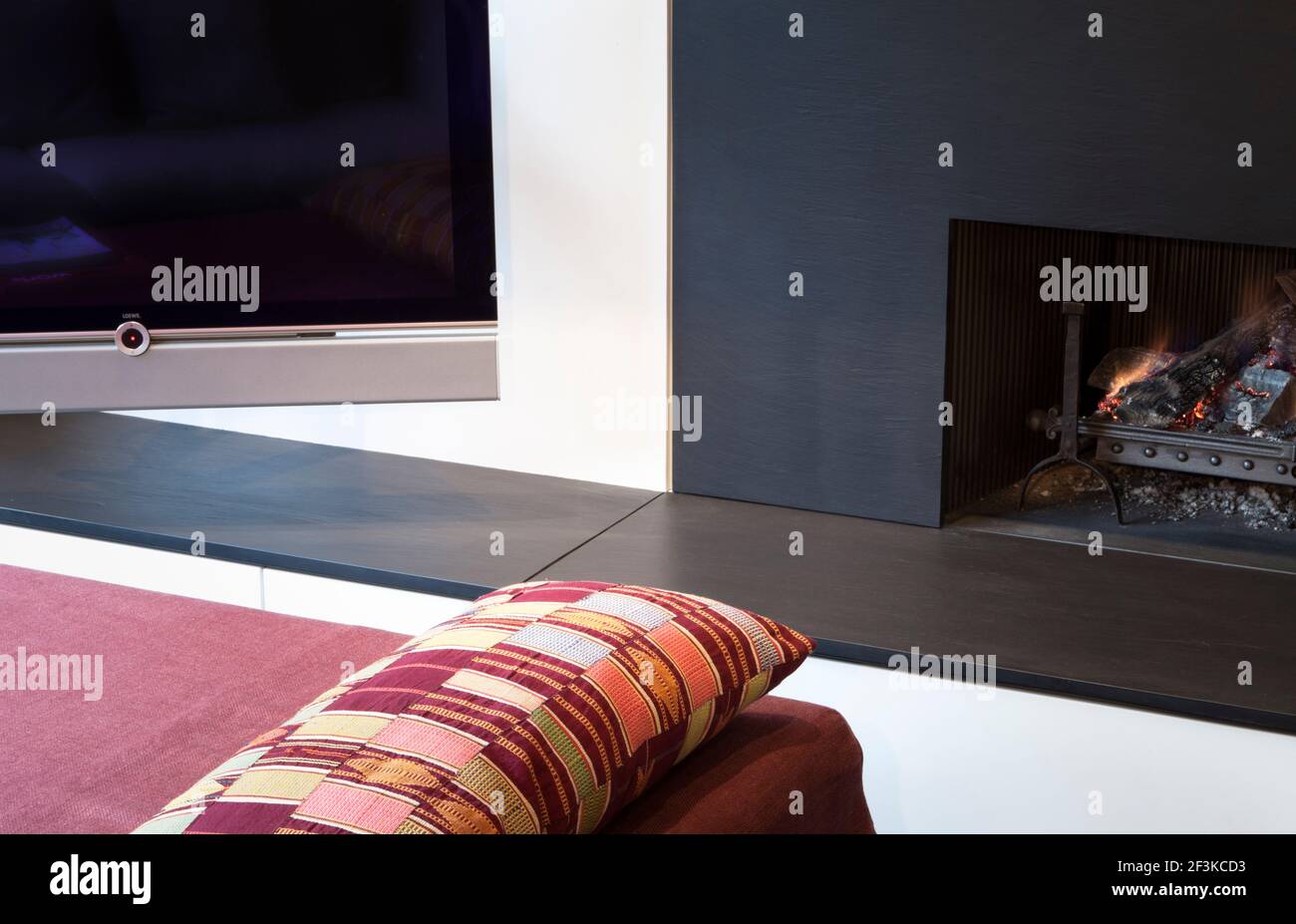 Coin salon avec TV Löwe et tabouret/table basse rembourré, Suita, par Antonio Citterio pour Vitra. Coussin recouvert de tissu ghanéen. Le feu entoure et Banque D'Images