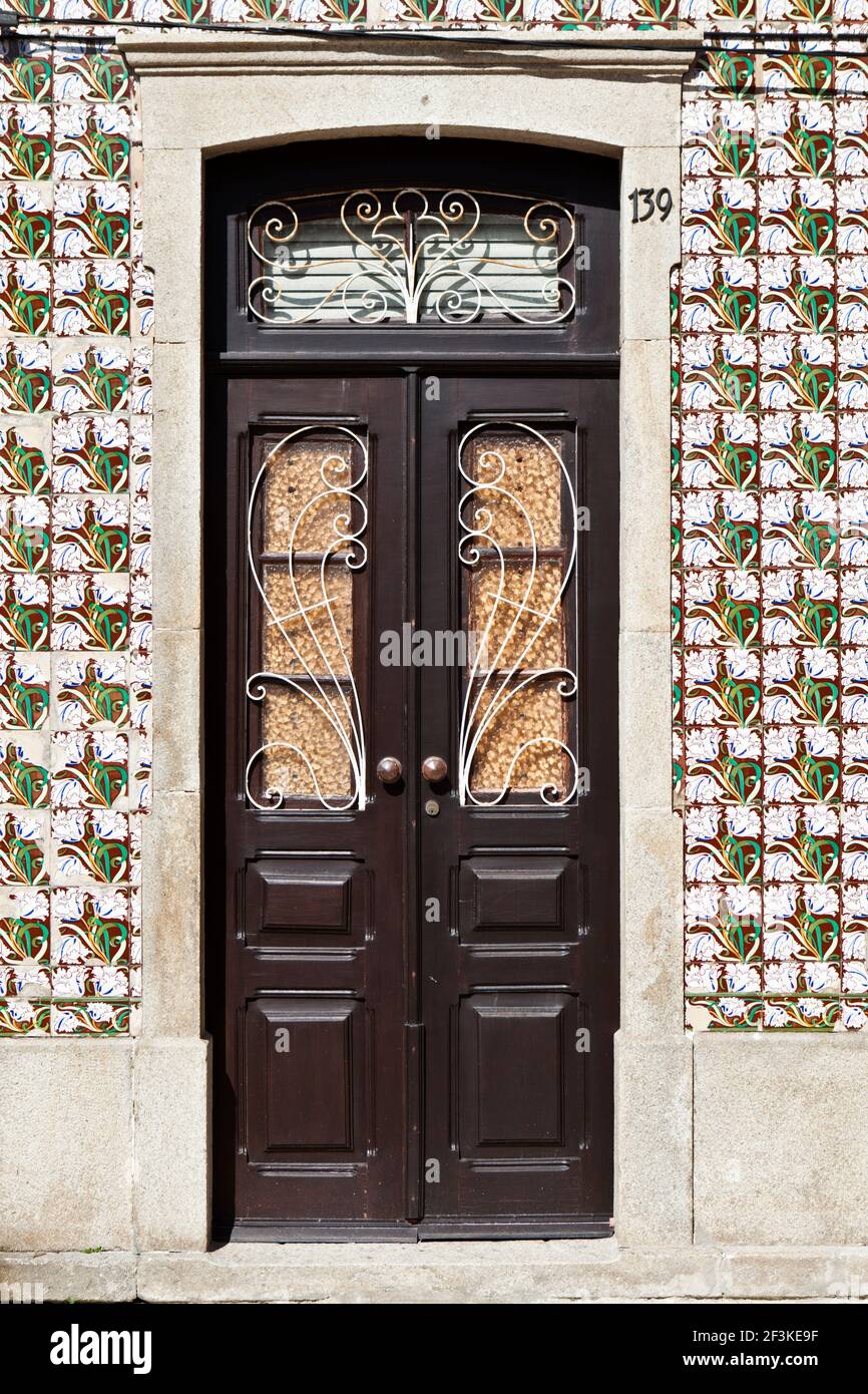 Motifs floraux peints sur carreaux azulejos entourent une porte traditionnelle en Ilhavo, Aveiro, Portugal Banque D'Images