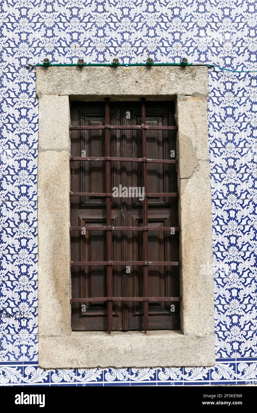 Une ancienne fenêtre barrée de fer entouré d'azulejo décoratifs tuiles, Ovar, Beira Litoral, Portugal Banque D'Images
