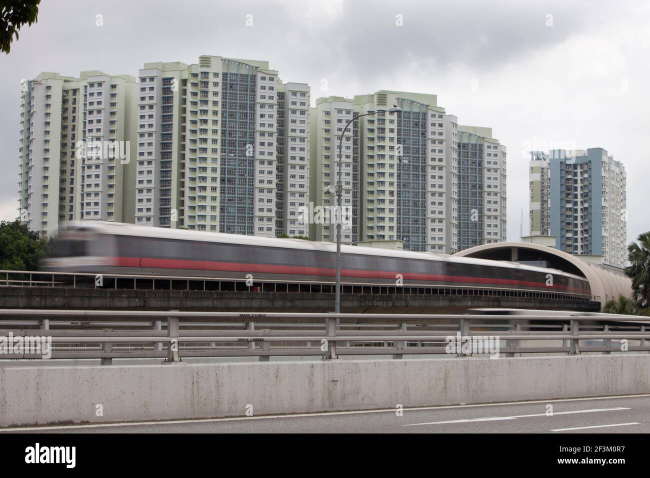Un métro passe devant un immeuble résidentiel de la périphérie de Singapour. Banque D'Images