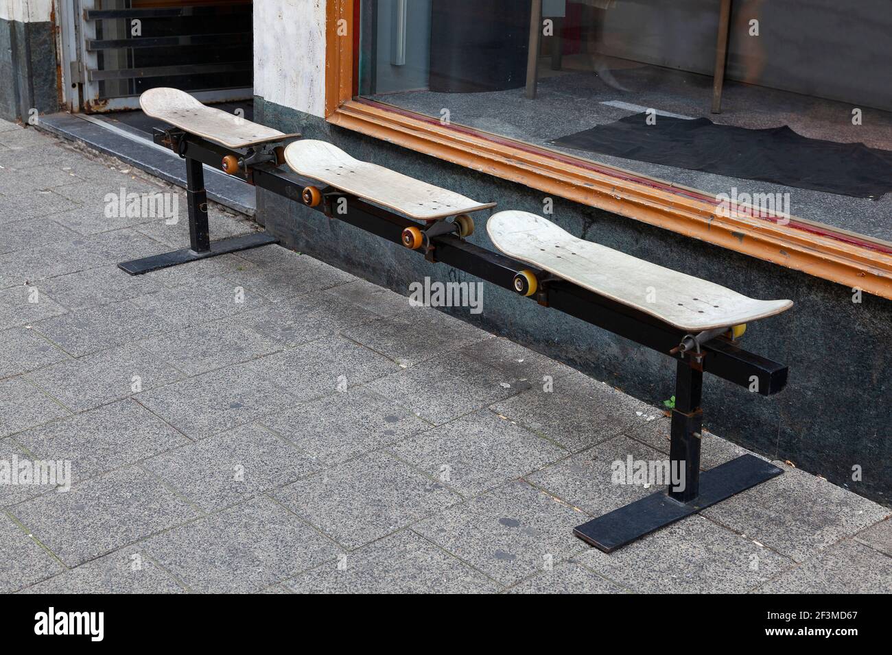 Deuxième utilisation d'un vieux skate-board en position assise banc à l'extérieur Banque D'Images