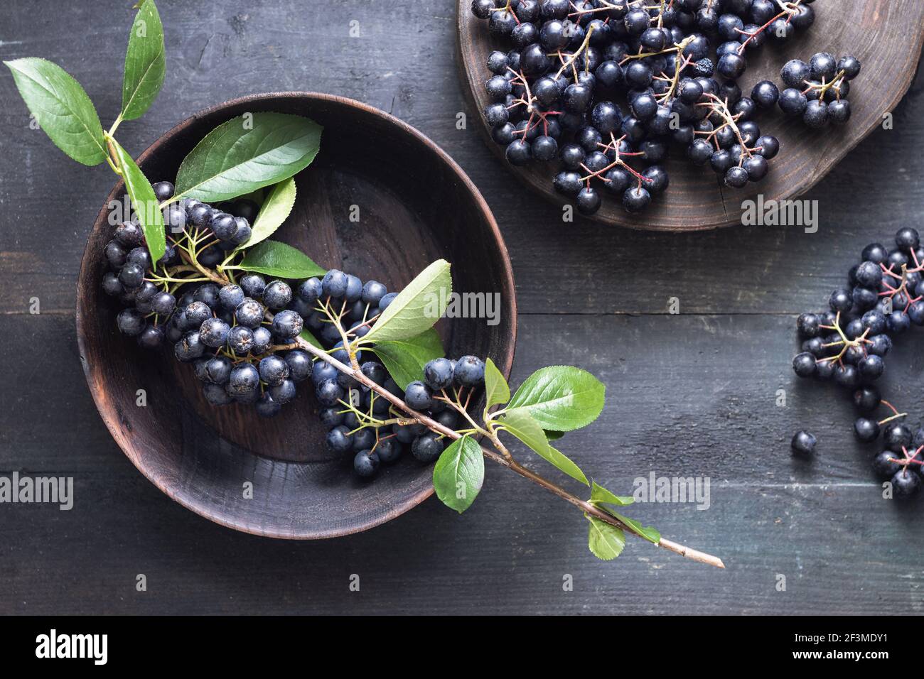 Baies d'aronia fraîchement cueillies sur table en bois Banque D'Images