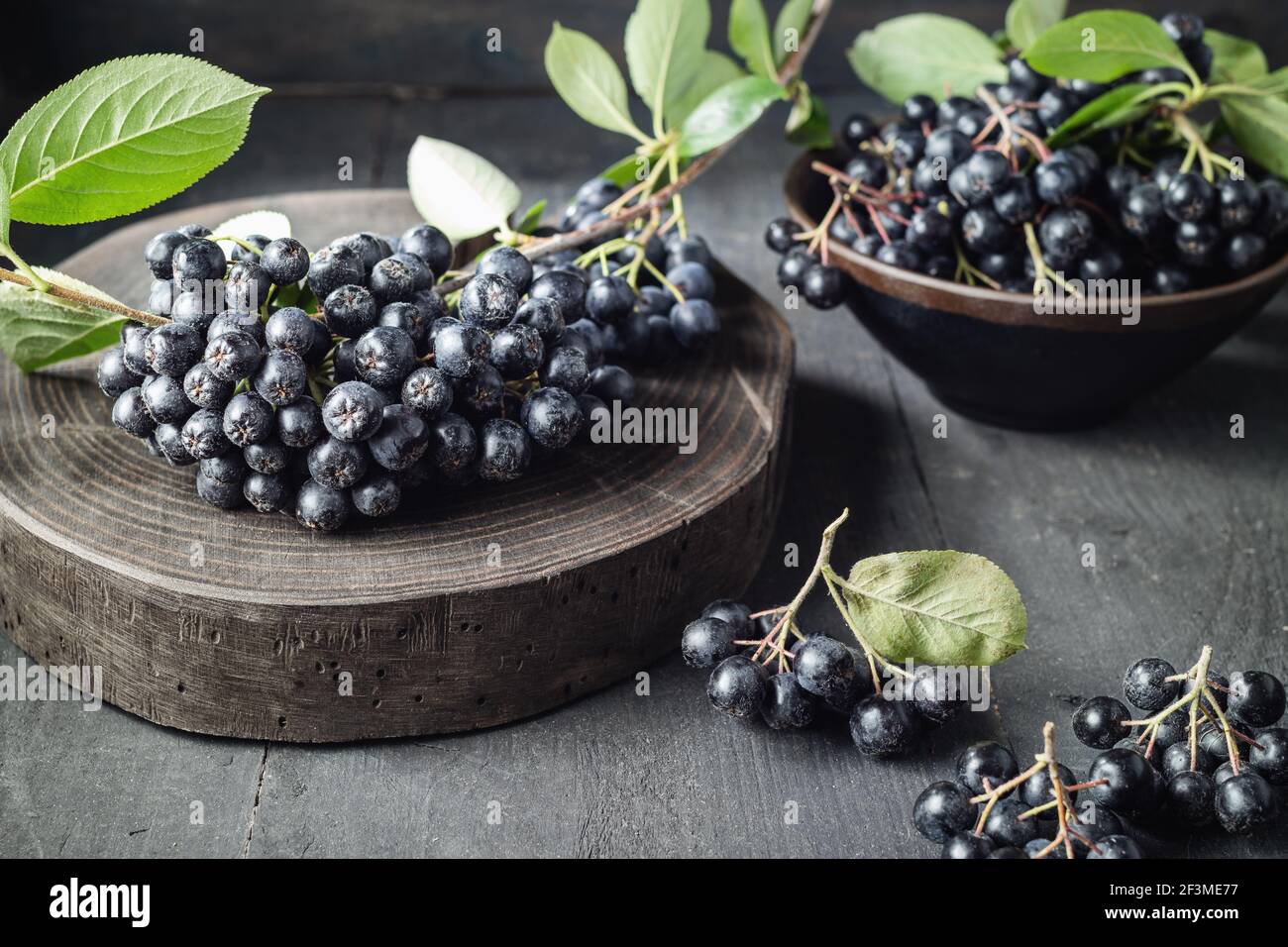 Baies d'aronia fraîchement cueillies sur table en bois Banque D'Images