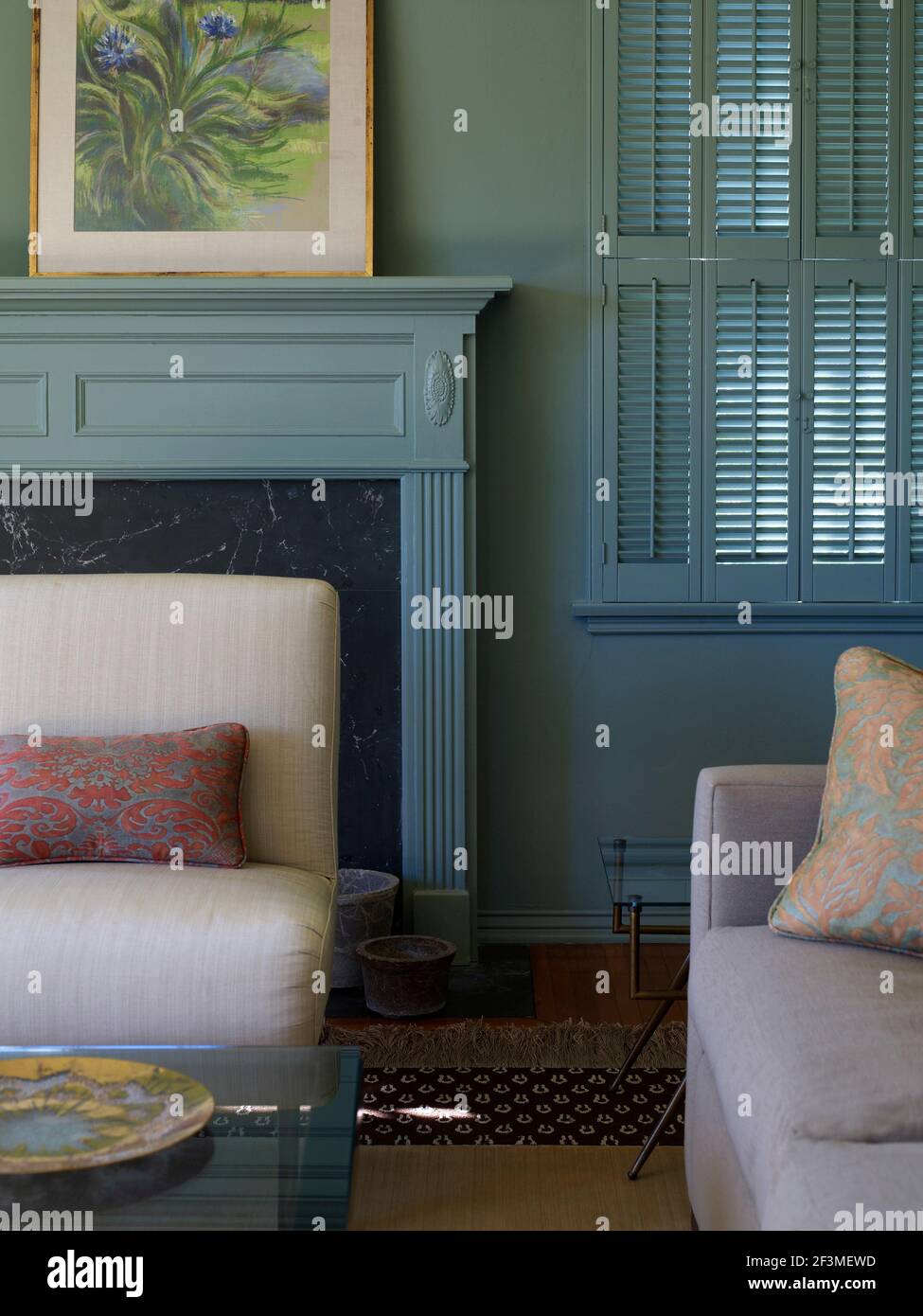 Canapés dans la salle de séjour avec mur bleu, cadre de fenêtre et feu entourent dans la maison résidentielle, Californie, Etats-Unis Banque D'Images
