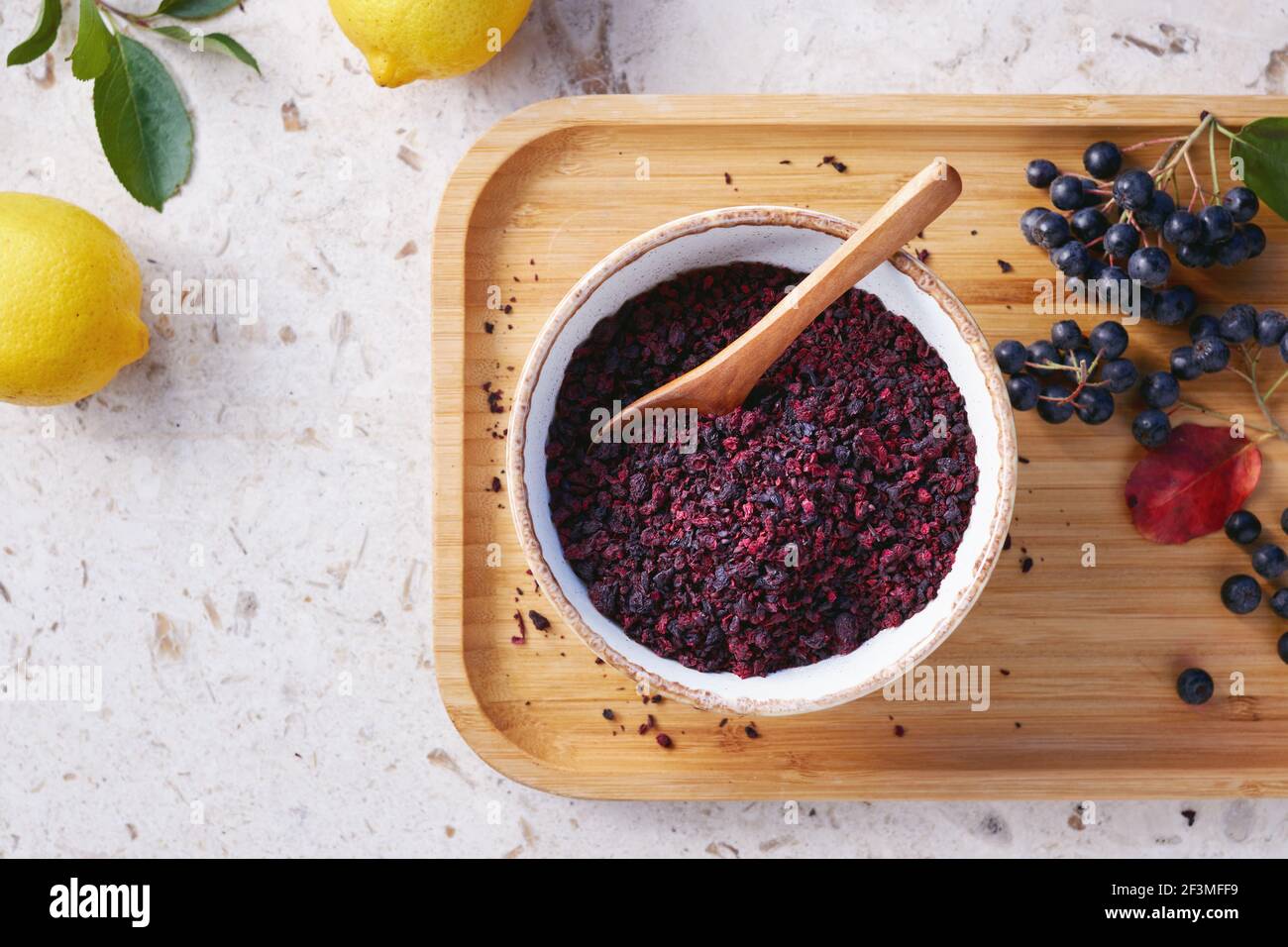 Thé aux baies Aronia dans un bol. Les baies d'aronia séchées sont couramment utilisées pour faire du thé riche en antioxydants. Banque D'Images
