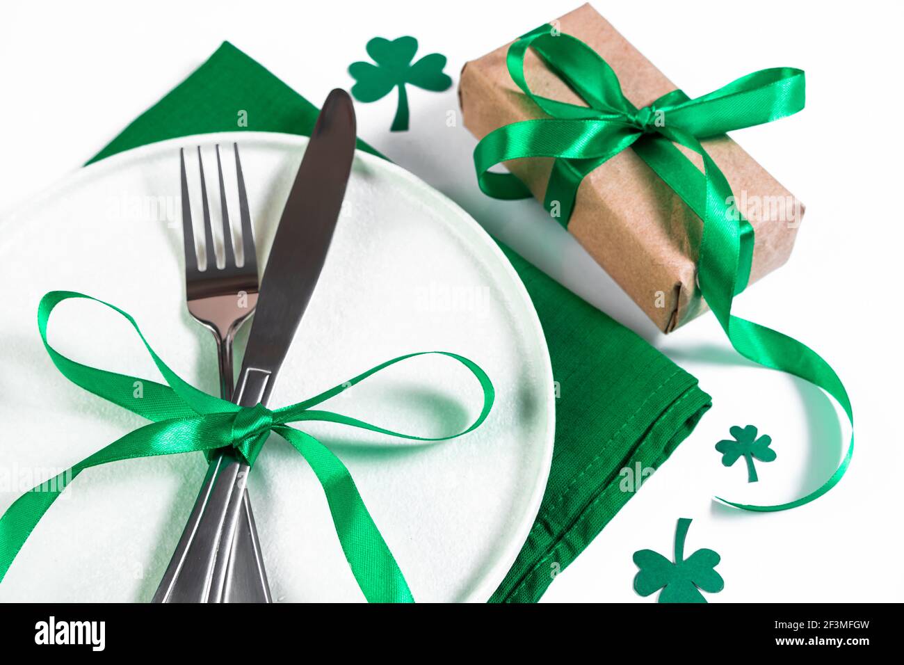 Table festive pour la Saint-Patrick. Assiette et couverts sur serviette verte. Shamrock symbole de chance. Banque D'Images