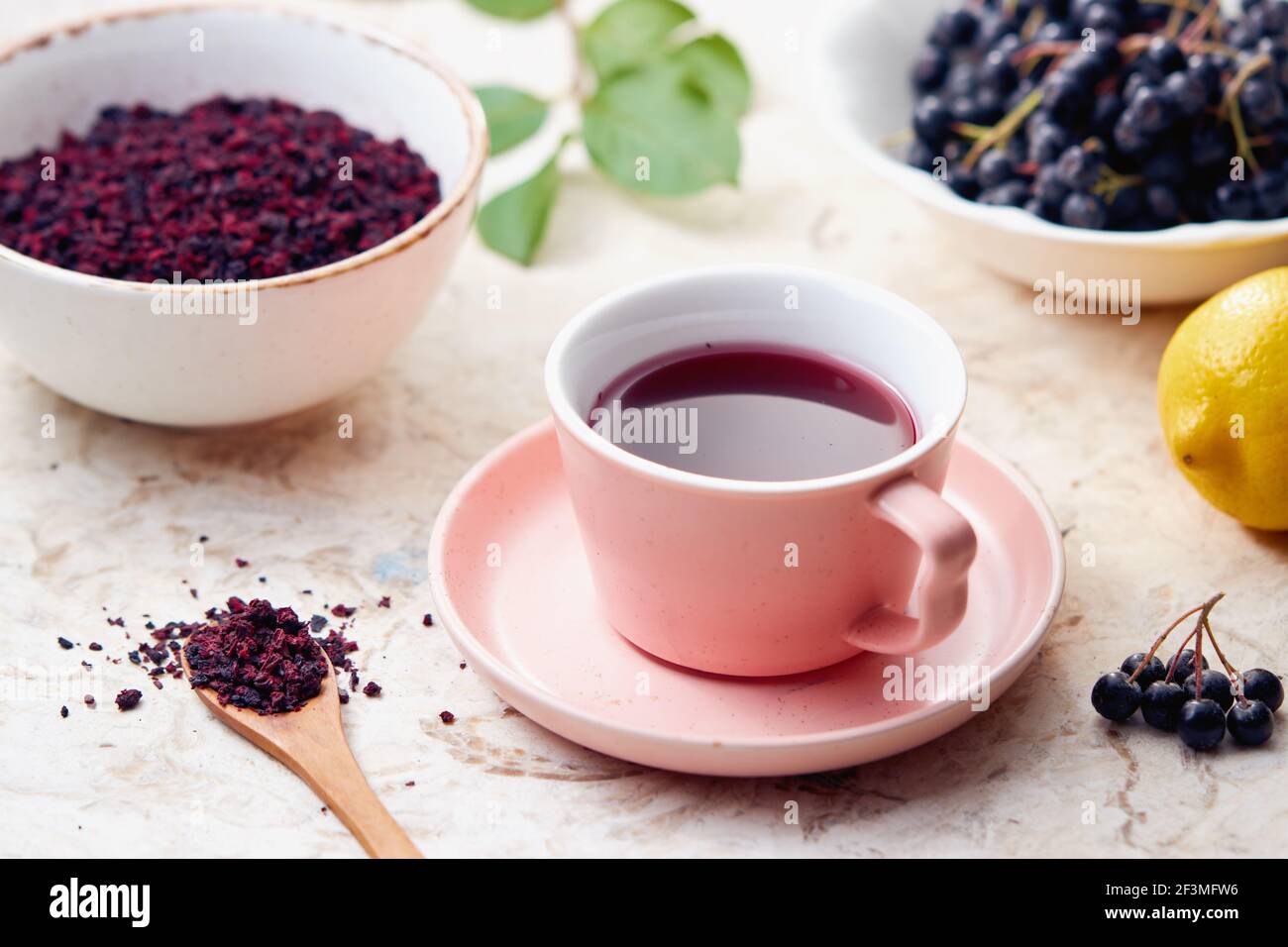 Thé aux baies Aronia dans une tasse. Les baies d'aronia séchées sont couramment utilisées pour faire du thé riche en antioxydants. Banque D'Images