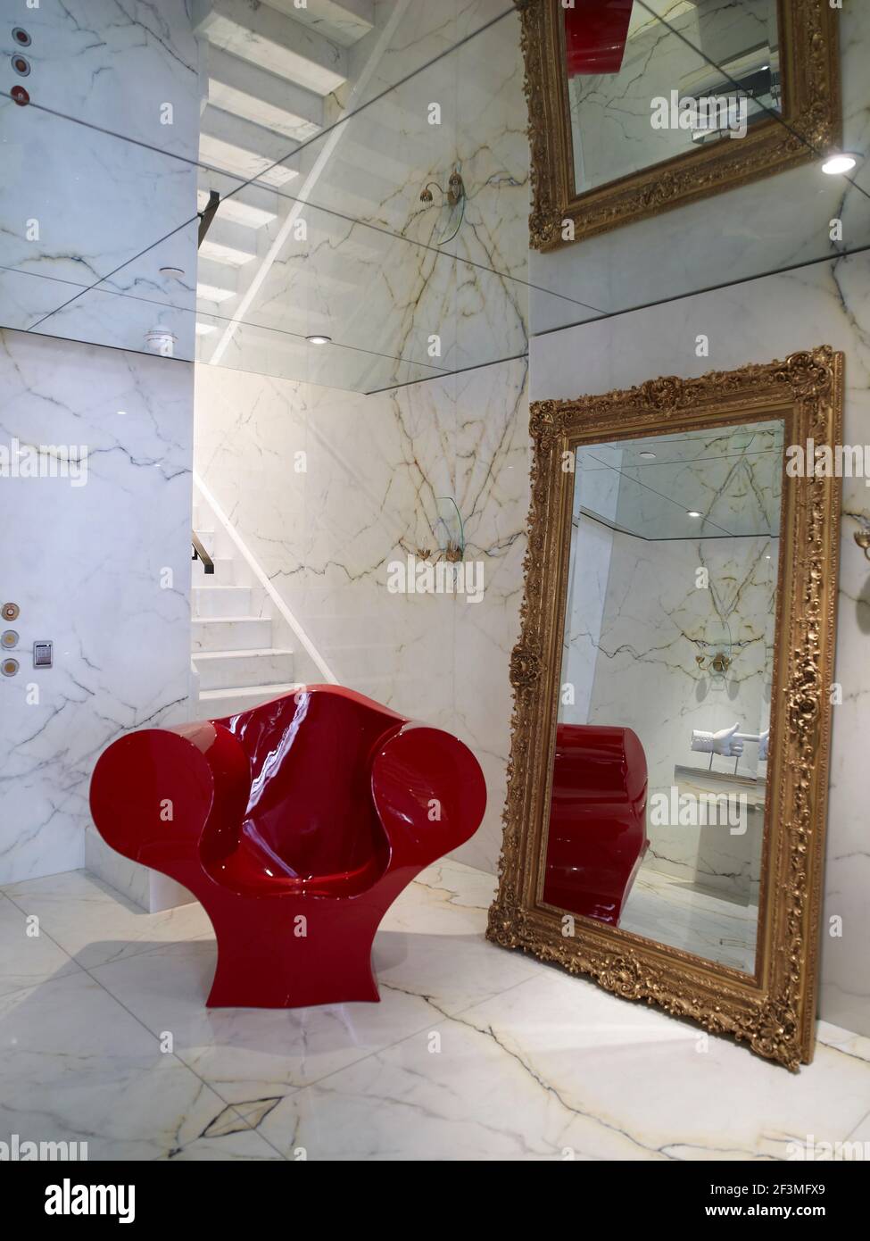 Chaise laquée rouge avec miroir encadré doré dans la maison résidentielle de New York, États-Unis, Banque D'Images