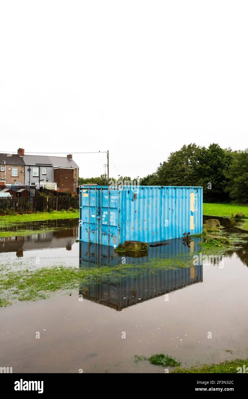 Un ancien conteneur d'expédition sur terre inondée Banque D'Images