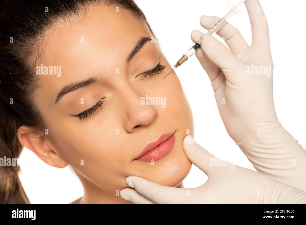 Portrait d'une jeune belle femme sur un visage de remplissage procédure d'injection sur fond blanc Banque D'Images