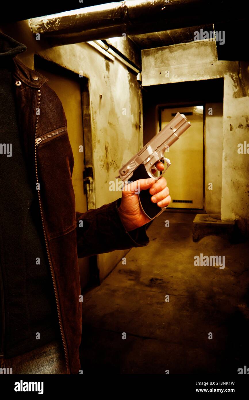 homme avec une arme à feu en main, image de crime mystère pour la couverture de livre Banque D'Images