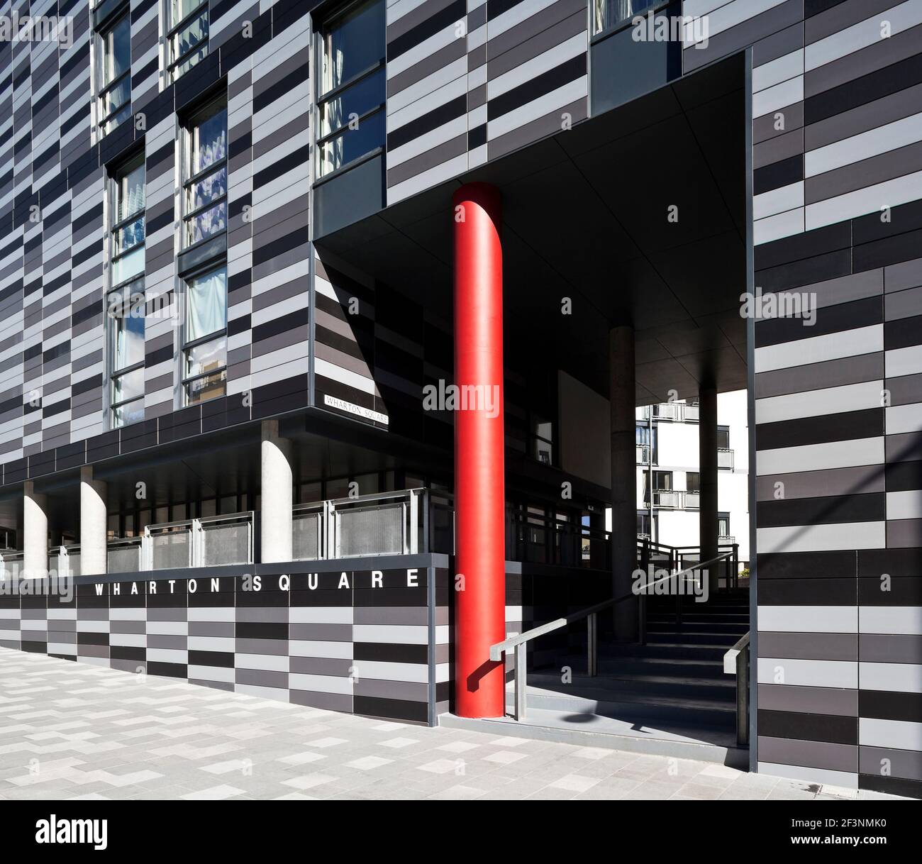 Wharton Square, social Housing avec panneaux horizontaux gris gradués à l'extérieur, agencer dans une forme octogonale autour d'une cour centrale. Rouge c Banque D'Images