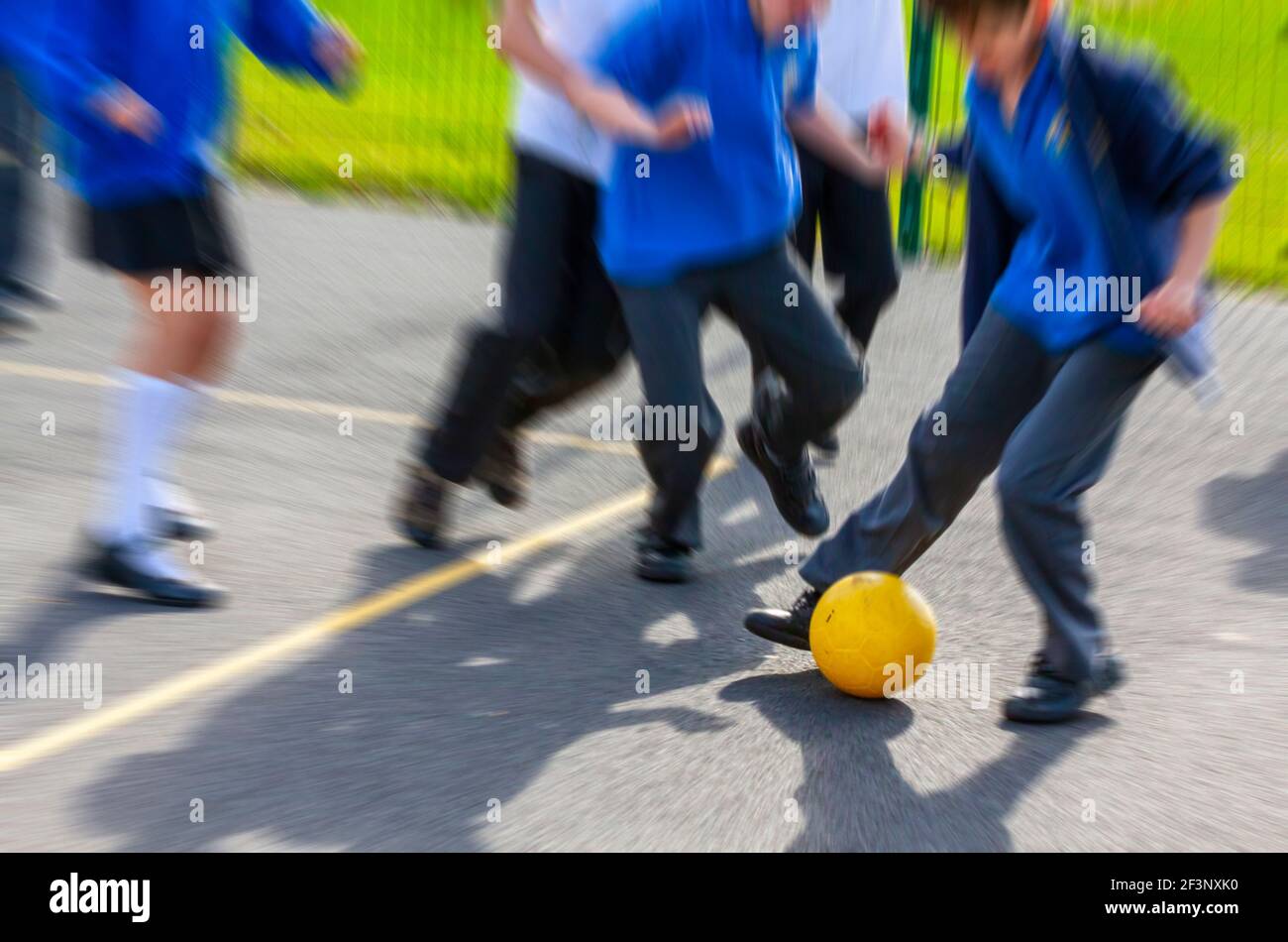 Les enfants de l'école primaire qui jouent au football en une pause de leurs cours de classe. Banque D'Images