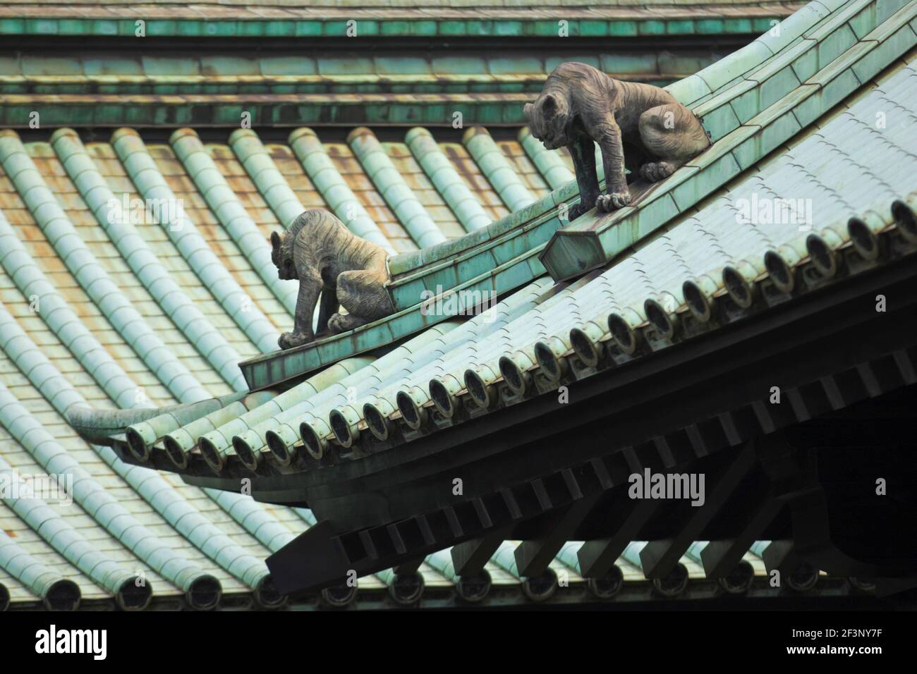 La conception du toit complexe est surveillée par des statues de gardien de lion komainu au temple Yushima-Seido, dans le vieux quartier de Kanda, dans le centre-ville de Tokyo, JAPA Banque D'Images