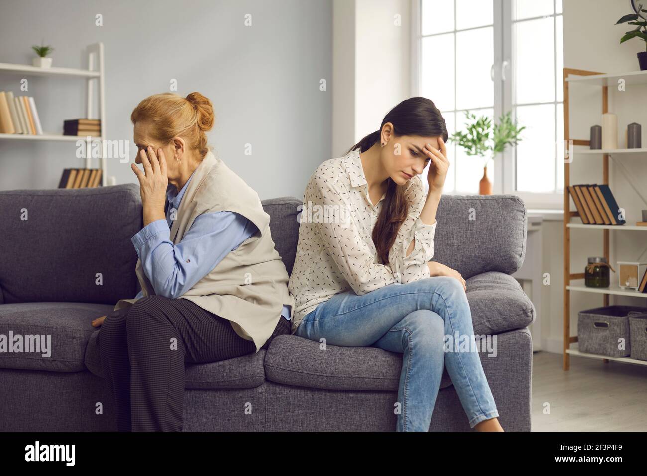 Mère âgée et fille adulte après querelle assise table de traitement séparée Banque D'Images