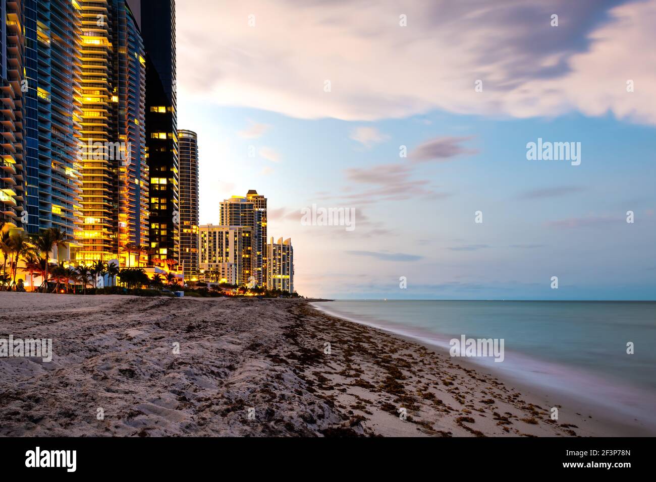 Exposition prolongée d'appartements d'hôtel ou de condominium au crépuscule du coucher du soleil à Sunny Isles Beach de Miami, Floride avec un ciel coloré Banque D'Images