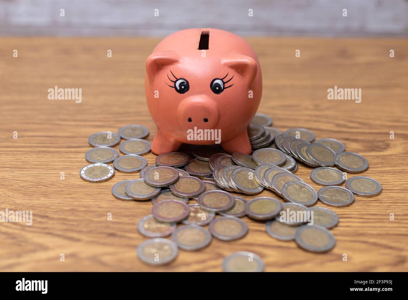 piggy en céramique rose à économiser sur un tas de deux pièces en euros dans le concept de comptabilité financière Banque D'Images
