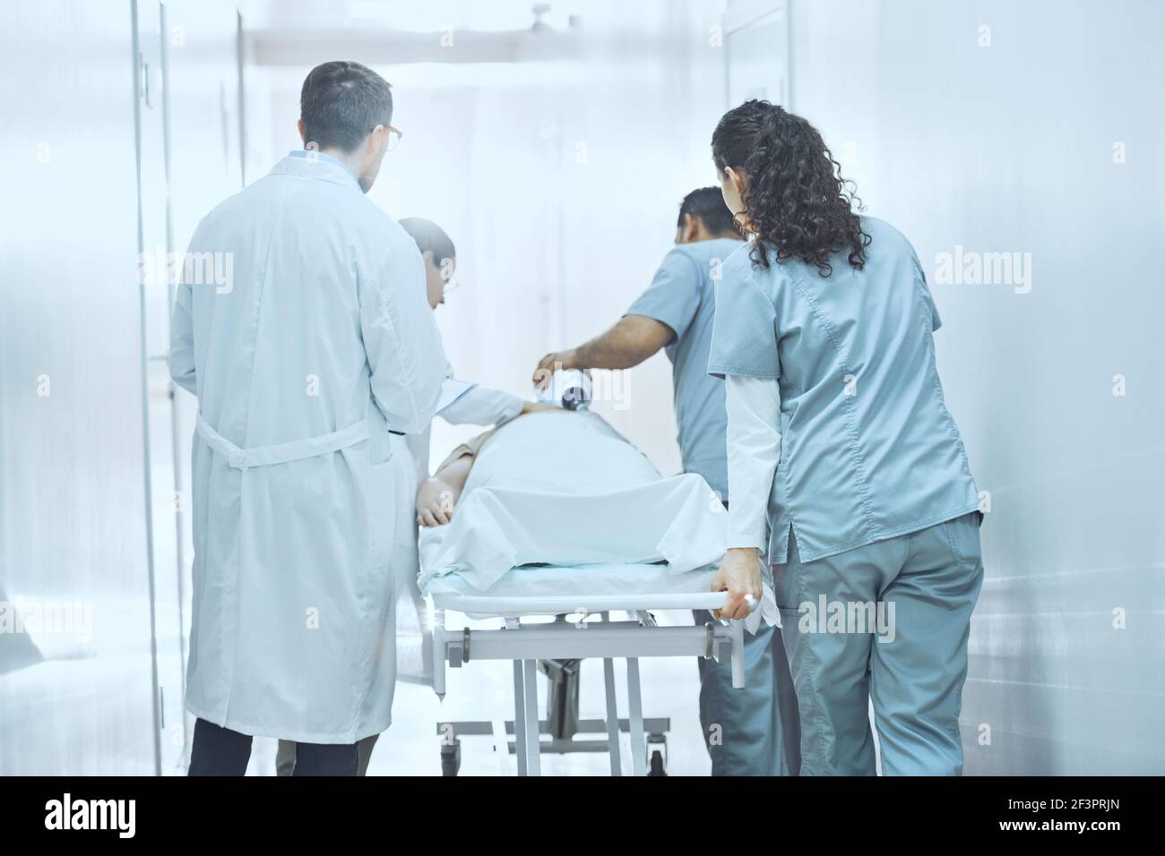 L'équipe médicale doit effectuer une réanimation cardio-pulmonaire en cas de blessure grave avec un masque à oxygène tout en poussant le brancard du brancard du brancard pour fonctionner Chambre Banque D'Images