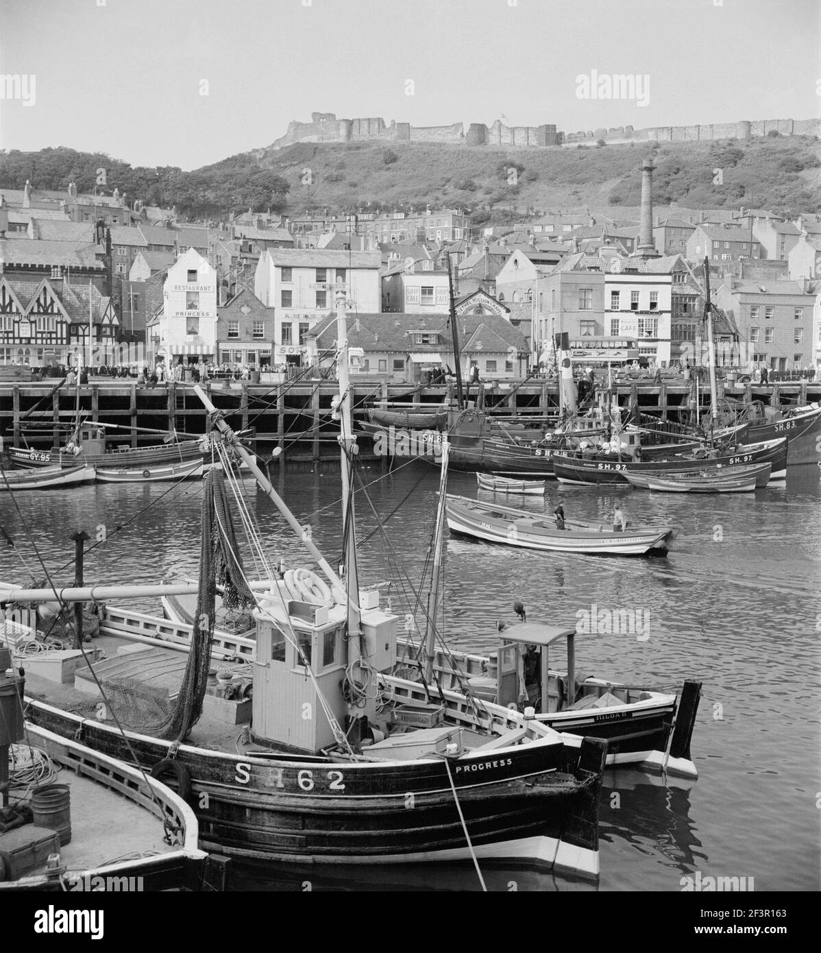 SCARBOROUGH, Yorkshire du Nord. Des bateaux de pêche amarrés dans le vieux port, regardant vers la ville avec le château dominant la colline derrière la ville. Banque D'Images