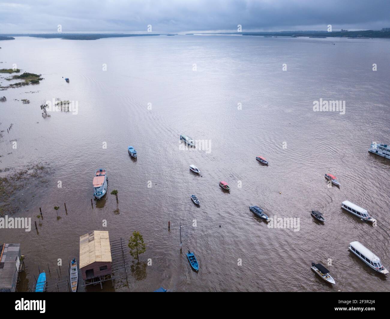 Vue aérienne drone de bateaux et maison communautaire, rivière Tapajos le jour d'hiver nuageux dans la forêt amazonienne. Itaituba, Para, Brésil. Concept d'écologie. Banque D'Images