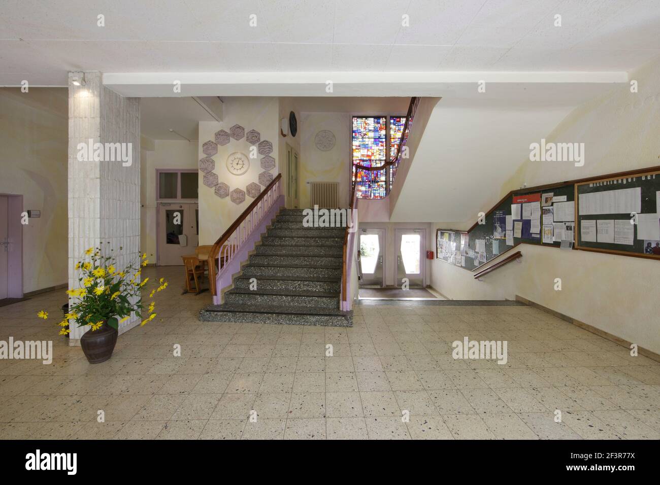 Entrée avec fleurs à côté de l'escalier en pierre menant à la vitrail dans l'école libre de Waldorf, Krefeld, Allemagne. C'était la seve Banque D'Images