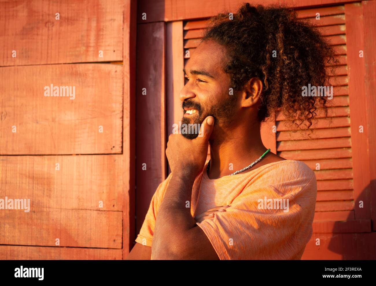 Joyeux homme noir. Cheveux longs et bouclés sur un jeune homme d'origine brésilienne. Concept d'espoir et de joie en cas de pandémie. Banque D'Images
