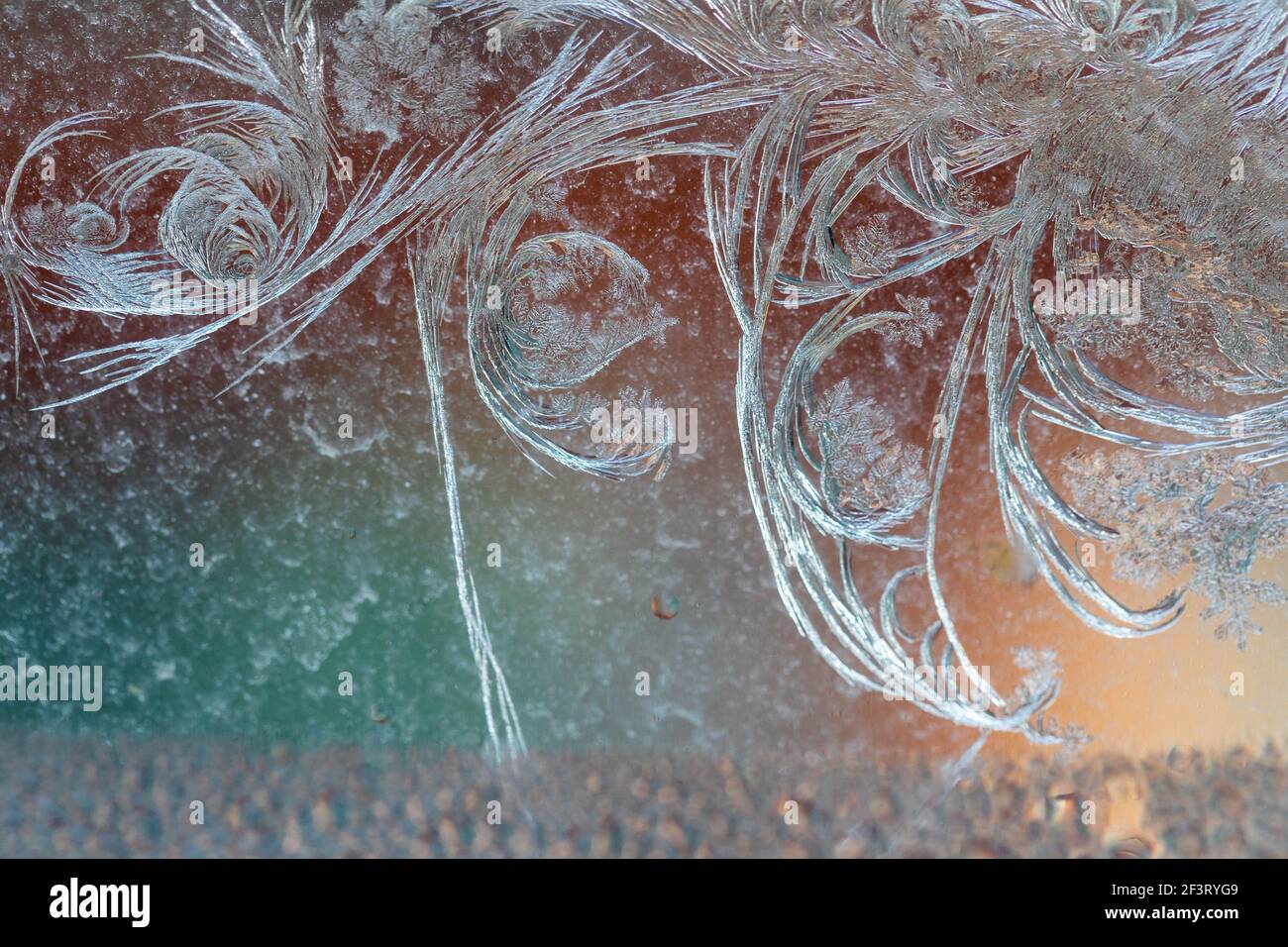 Des gravures Jack Frost sur la fenêtre, avec un arrière-plan coloré. Banque D'Images