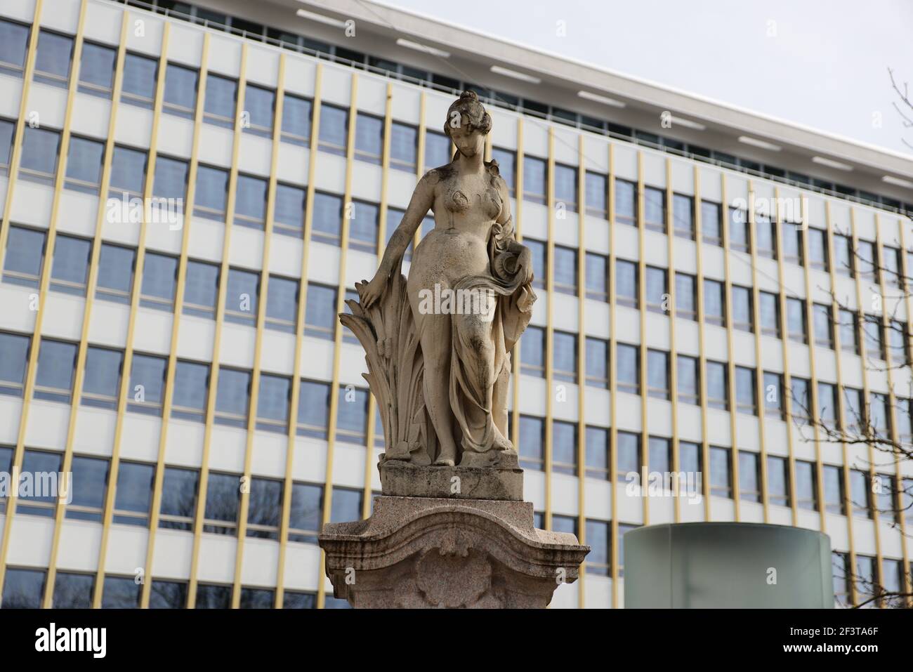 statue de femme en grès brun antique devant le gratte-ciel, idéale pour les compositions photographiques Banque D'Images