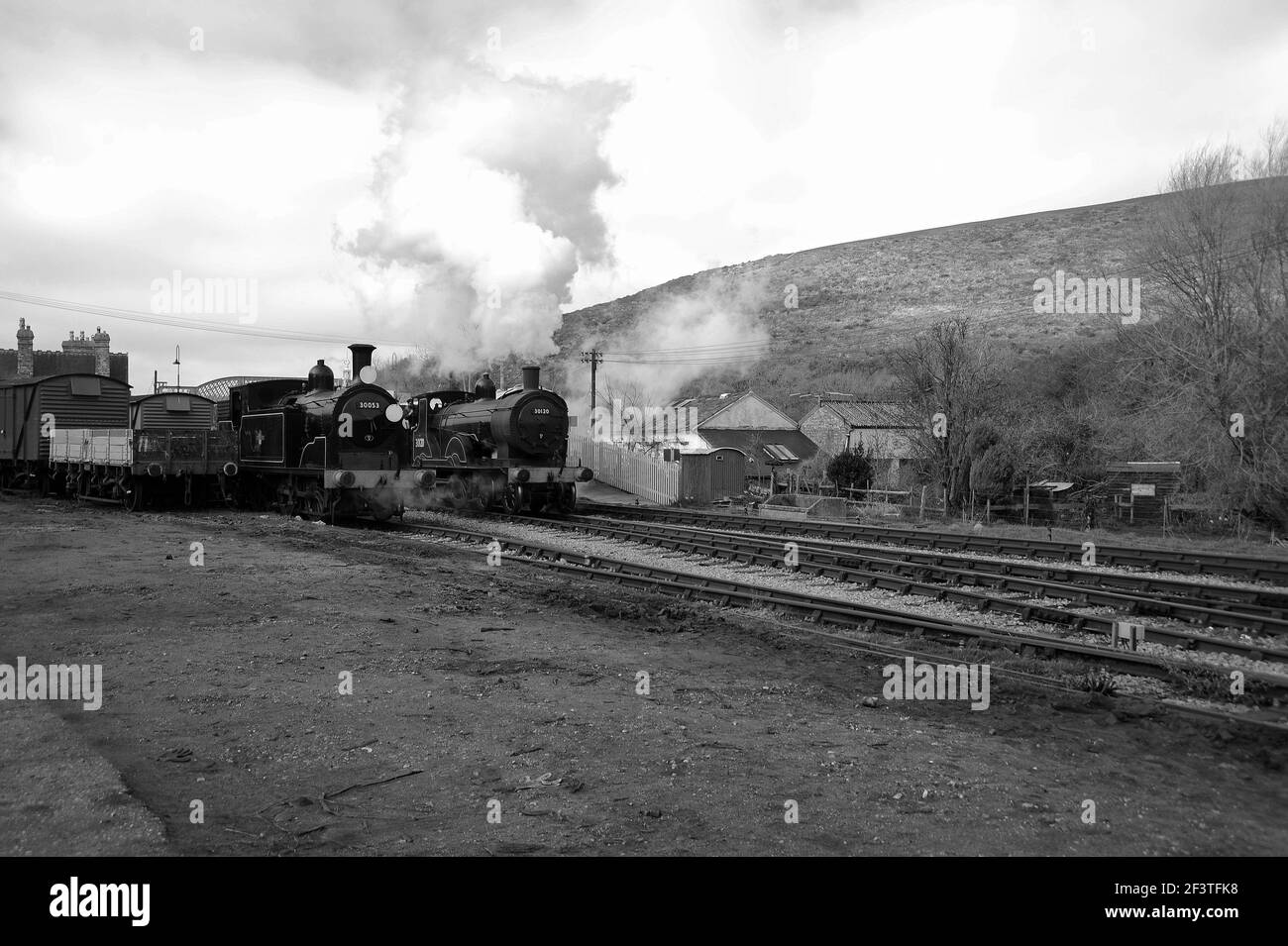 '30053' dans la cour de marchandises du château de Corfe, comme '30120' (avec 'Manston' derrière) passent par la gare. Banque D'Images '30053' dans la cour de marchandises du château de Corfe, comme '30120' (avec 'Manston' derrière) passent par la gare. Banque D'Images