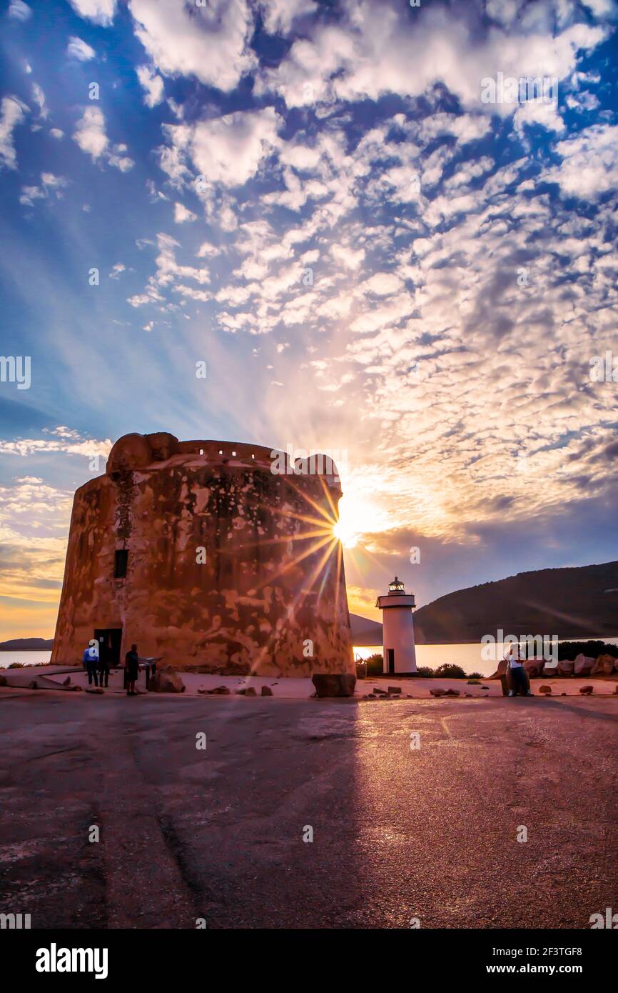 Contre-jour de la nouvelle Tour et du phare de Porto Conte, Sardaigne au coucher du soleil sous un ciel de haut-fond Banque D'Images