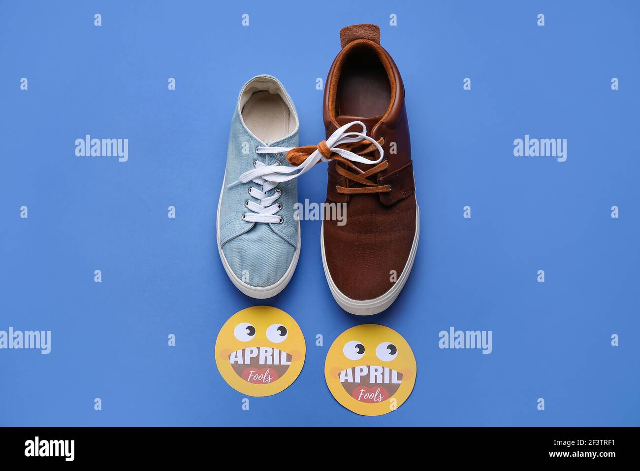 Différentes chaussures avec lacets attachés sur fond de couleur. Le jour de  la fête de la Fool d'avril Photo Stock - Alamy