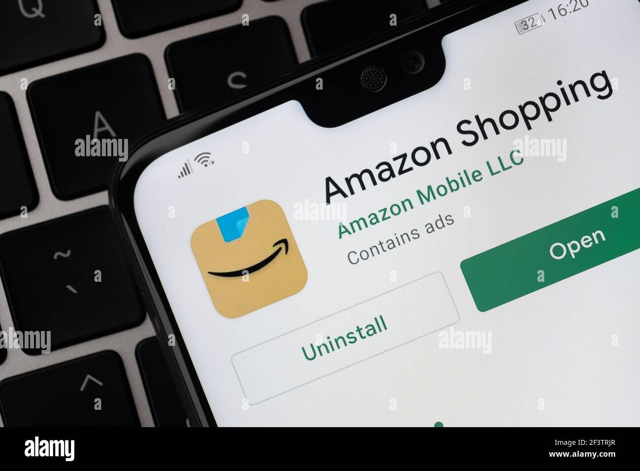 L'application Amazon Shopping s'affiche sur l'écran du smartphone qui est placé sur le clavier de l'ordinateur portable. Stafford, Royaume-Uni, 14 mars 2021 Banque D'Images