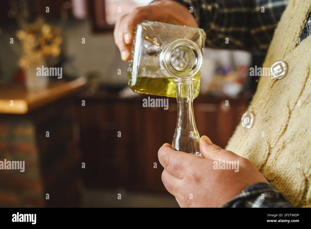Gros plan sur les mains d'un inconnu qui déversait le serbe traditionnel les croates bosniaques ou macédoniens boivent de l'alcool brandy rakija ou slivovitza en prune i Banque D'Images