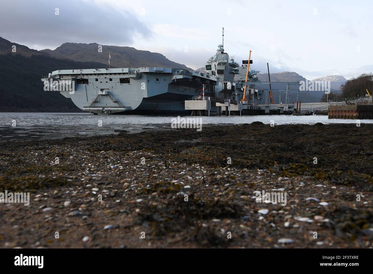 Finnart, Loch long, Écosse, Royaume-Uni. 17 mars 2021. PHOTO : le HMS Queen Elizabeth est le plus grand et le plus avancé des navires de guerre jamais construits pour la Marine royale. Le HMS Queen Elizabeth (en photo) et le HMS Prince of Wales sont les navires-drapeaux du pays qui pèsent 65,000 tonnes et mesurent 280 mètres de longueur. Le porte-avions est actuellement amarré sur le côté de long Loch à Glen Mallan pour prendre du carburant, des munitions et d'autres fournitures, avant les exercices navals qui font partie du groupe d'attaque britannique Carrier Strike Group 2021. Le bateau doit partir le dimanche. Crédit : Colin Fisher/Alay Live News. Banque D'Images