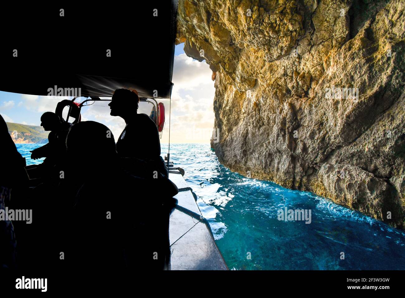 Un bateau touristique visite l'intérieur de la grotte de l'œil bleu près de Paleokastritsa sur l'île de Corfou, en Grèce. Banque D'Images