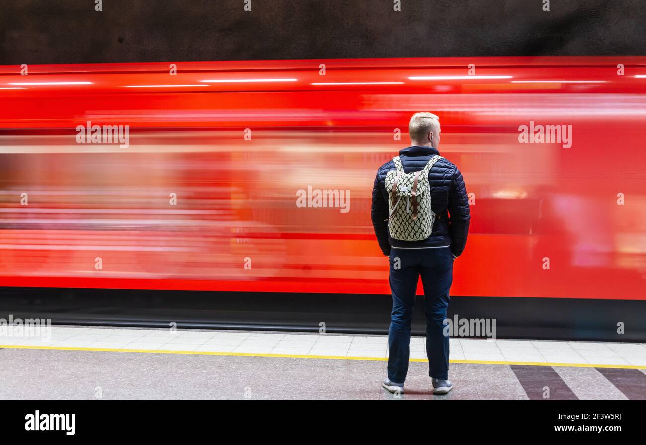 Jeune homme regardant le passage du métro dans le métro Hakaniemi Gare d'Helsinki, Finlande Banque D'Images Jeune homme regardant le passage du métro dans le métro Hakaniemi Gare d'Helsinki, Finlande Banque D'Images