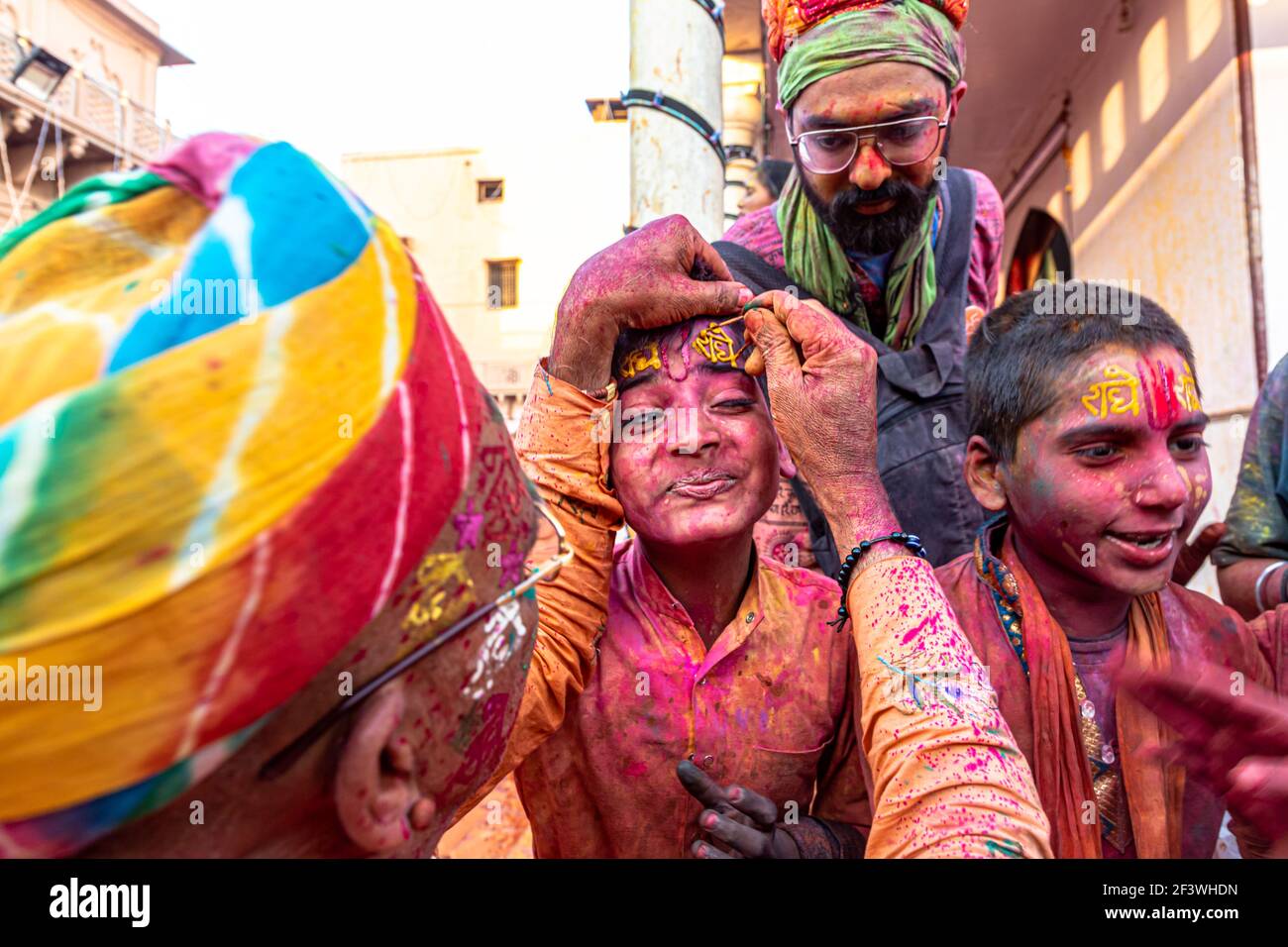 un homme met des couleurs sur le festival holi en inde avec un accent sélectif sur le sujet et ajouté du bruit et des grains. Banque D'Images