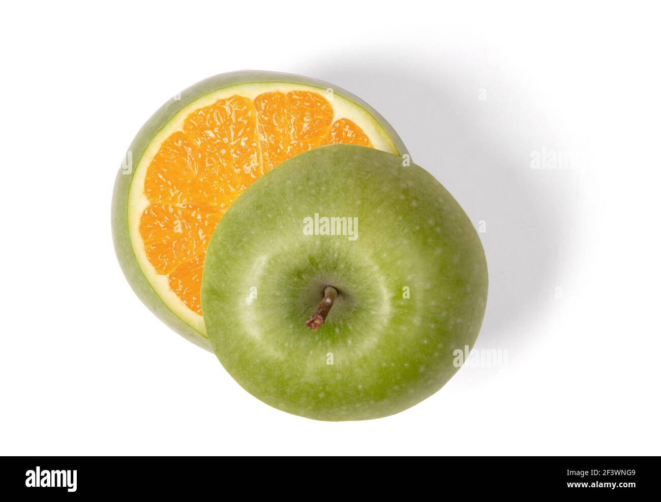 Pomme verte avec orange à l'intérieur, isolée sur blanc Banque D'Images