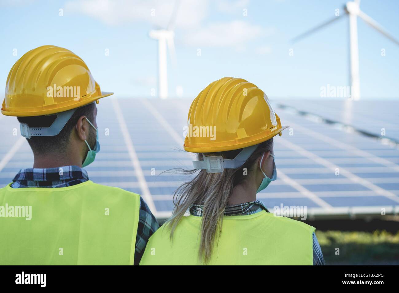 Travailleurs industriels travaillant à la centrale solaire tout en portant la sécurité Masques - Focus sur la tête de la femme Banque D'Images