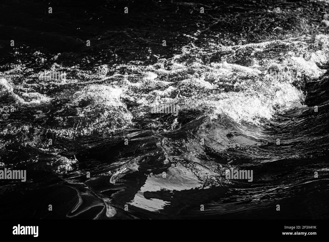 eau bouillonnante avec mousse et éclaboussures. photo noir blanc. Photo de haute qualité Banque D'Images