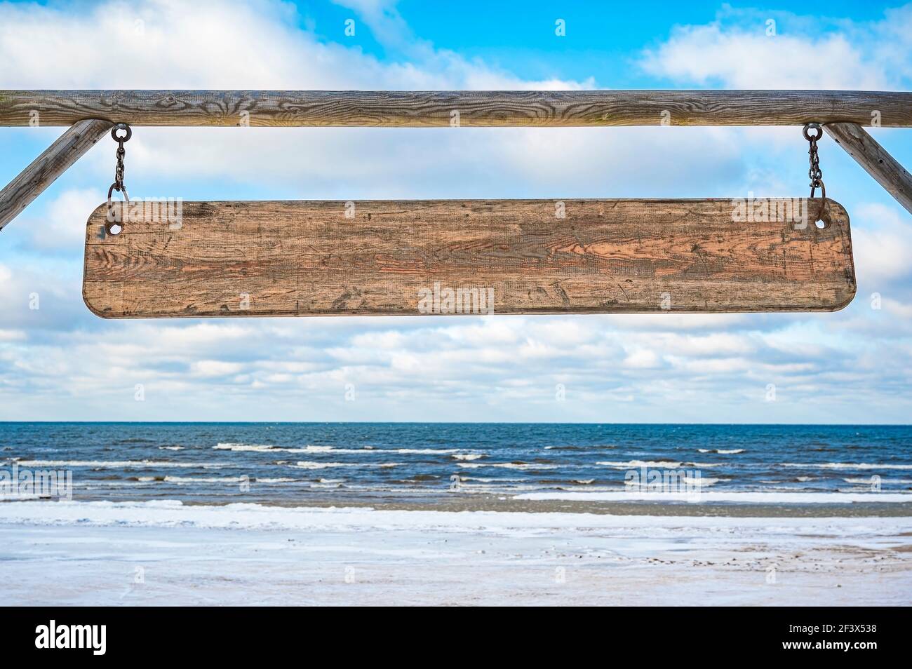 Panneau en bois avec espace de copie contre ciel bleu et mer avec fond de vagues. Panneau en bois vierge. Banque D'Images