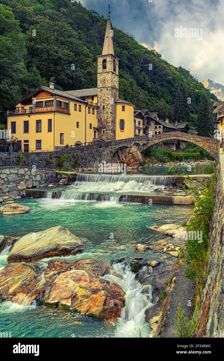 Le village alpin de Fontainemore, dans la vallée de Lys, avec son pont romain qui traverse le ruisseau alpin des Lys. Aoste, Val d'Aoste, Italie Banque D'Images