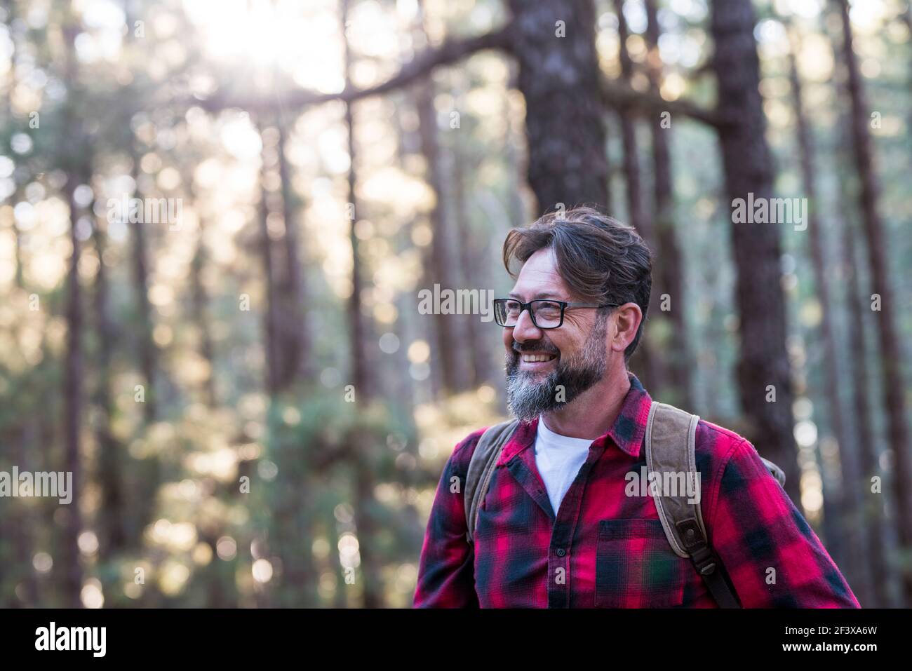 Portrait en gros plan d'un homme à barbe confiant dans un parc extérieur. Profil jeune beau sourire barbu homme Jeune adulte hipster randonnée forêt - Happy peo Banque D'Images